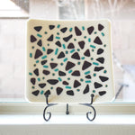 Square kiln formed glass tray in vanilla cream with accents of black and peacock green.