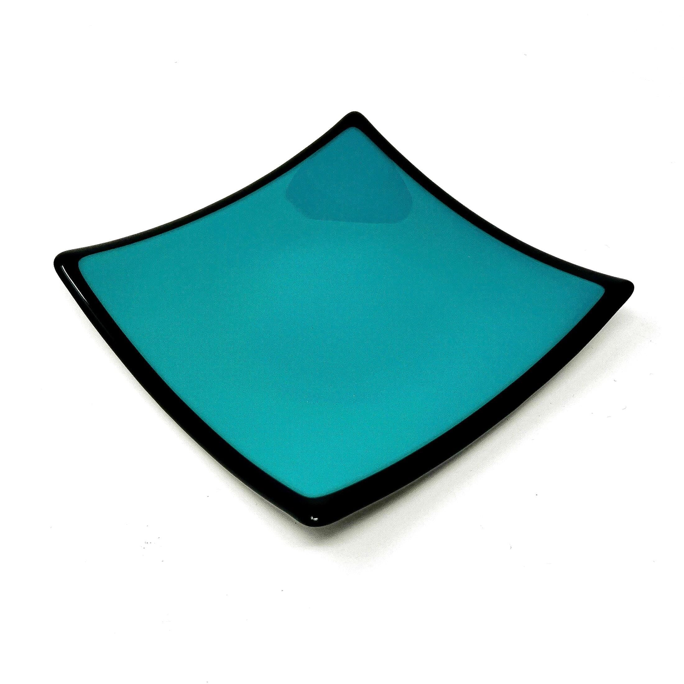 Square glass dish in teal green with black rim in front of white background