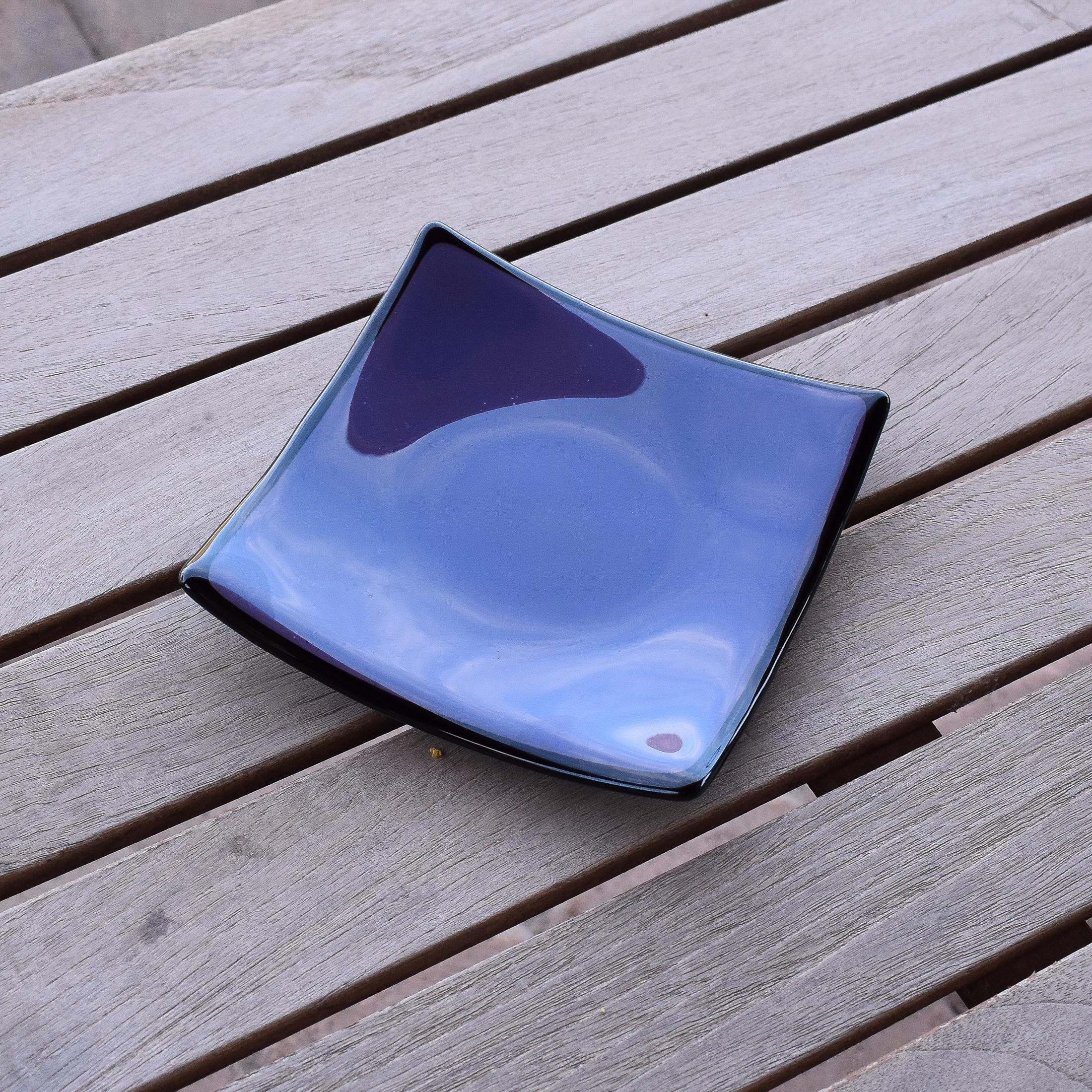 Dusty Violet Purple fused glass tray with black trim sitting on wooden table. Tray is 6" square.