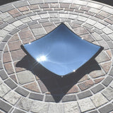 Chambray Blue fused glass dish with black trim and black base. Square with a slight slope at each corner. Sitting on stone table.
