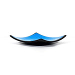 Square fused glass dish with solid blue center, black trim and black base, sitting white surface.