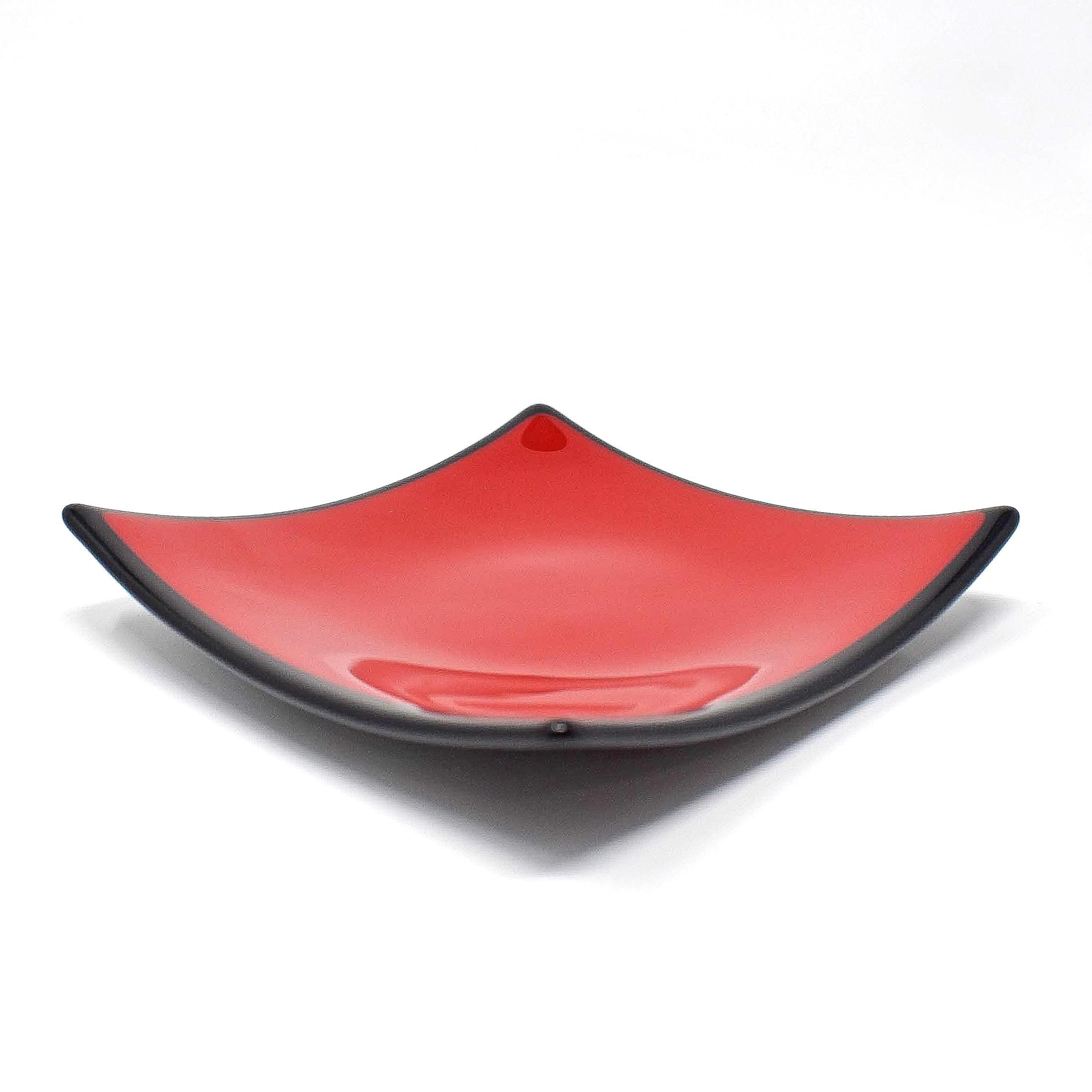 A square-shaped glass dish with a red interior and a black rim.