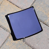 Dusty Violet Purple fused glass tray with black trim sitting on pavers in sunlight. Tray is 6" square.