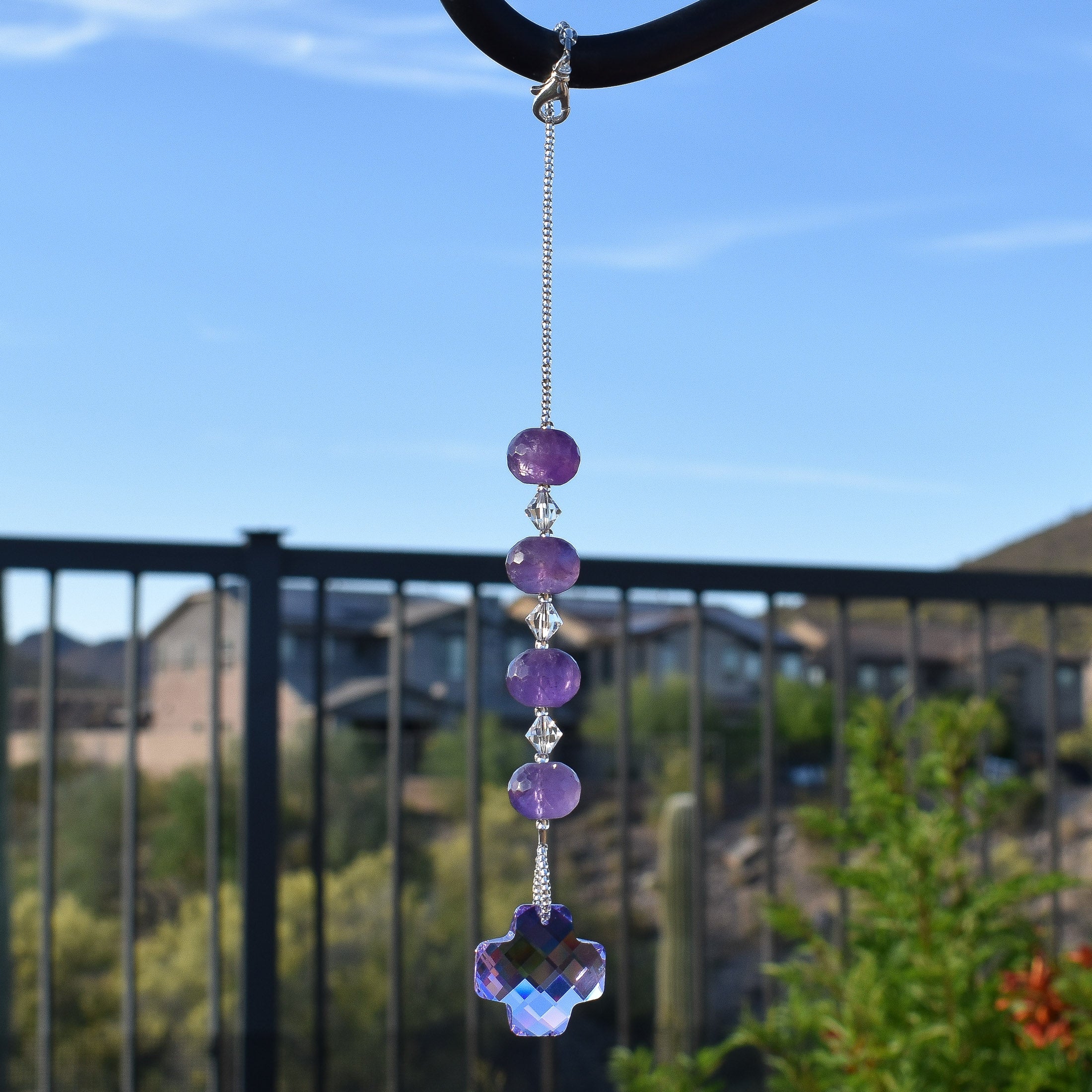 Amethyst beads paired with small clear crystal beads and anchored by a large, faceted, purple crystal pendant, hanging vertically.