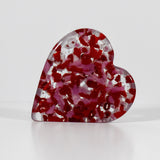 Heart-shaped solid glass paperweight standing on one side of the heart, pink and red with clear and white glass, 4-1/2&quot; tall. white background